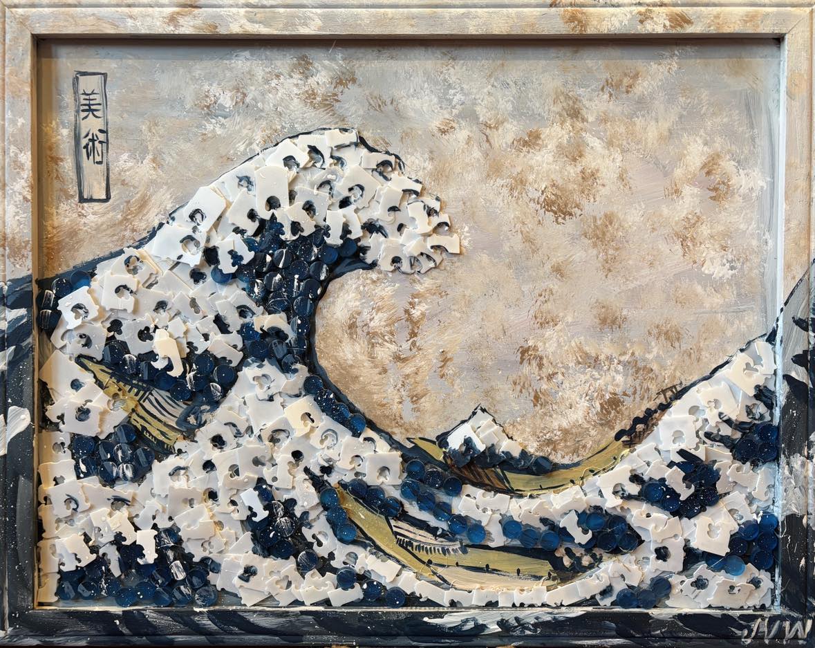 Reuse-art interpretation of a great wave, built from white and blue puzzle pieces and bottle caps on a weathered cork board