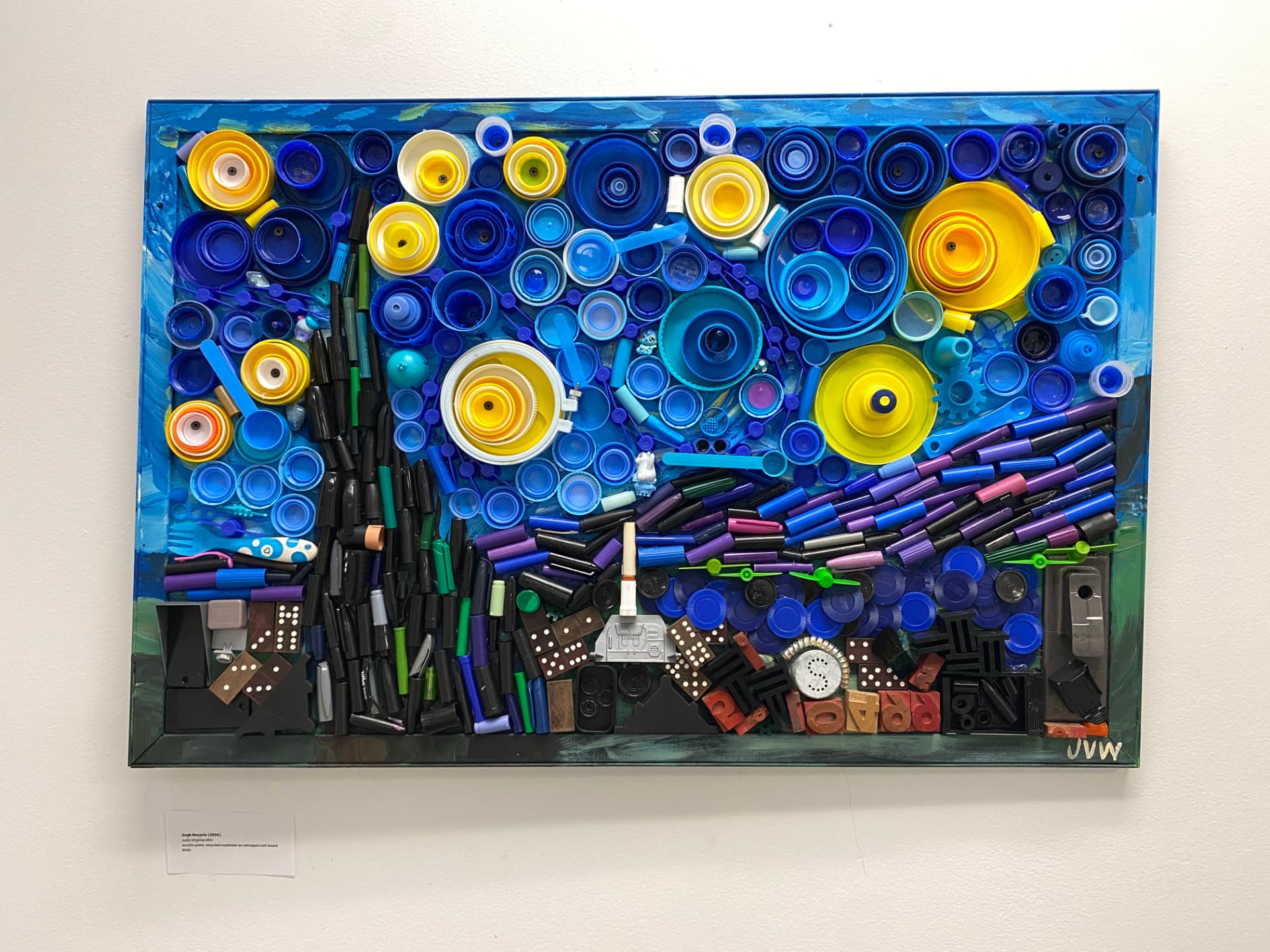 Framed reuse-art seascape of Cape May made from blue and yellow bottle caps, marker caps, dominoes and other salvaged objects