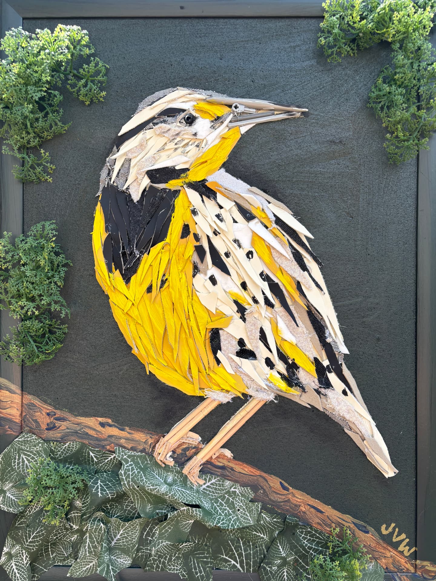 Fabric collage of a yellow and black Eastern meadowlark perched on a branch, built from torn cloth and textile scraps